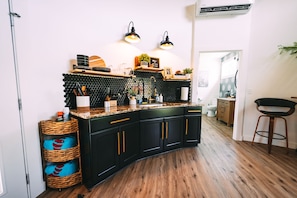 Una cocina moderna con gabinetes negros, encimera de madera y un salpicadero hexagonal negro.