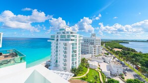 Ein Hochhaus-Hotel mit mehreren Etagen, einem Dachpool und Blick auf das Meer.