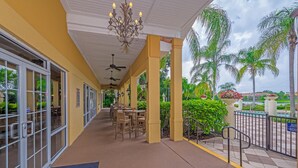 A covered outdoor area with tables and chairs, a ceiling fan, and a chandelier. - 3012- Great Family Home near Disney (private pool) (Kissimmee)
