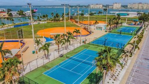 Ein Sportkomplex mit mehreren Tennisplätzen, einem Baseballfeld und einem Imbissstand.