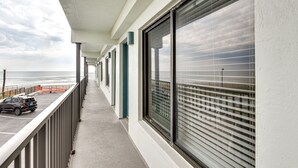 A balcony with a view of the ocean, a parked car, and a railing. - Daytona Beach Vacation Rental w/ Ocean Views! (Daytona Beach)