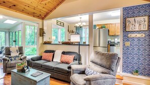 A spacious living room with a gray sofa set, a coffee table, and a view of the kitchen through an open doorway. - 10 Mi to Sugar Mtn: ‘Bluebird Cottage’ in Newland (Newland)
