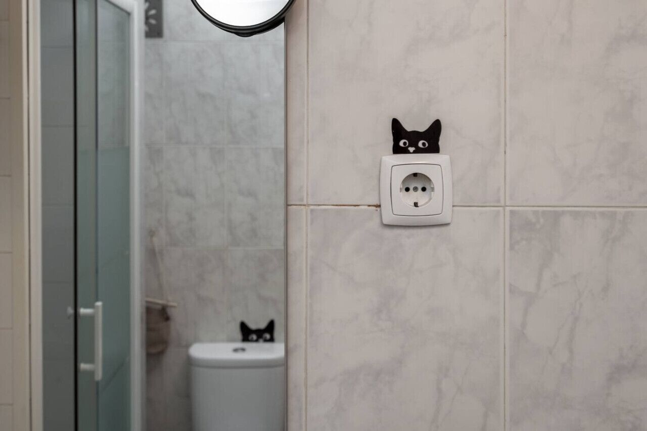Un bagno con piastrelle in marmo, cabina doccia in vetro e un water.