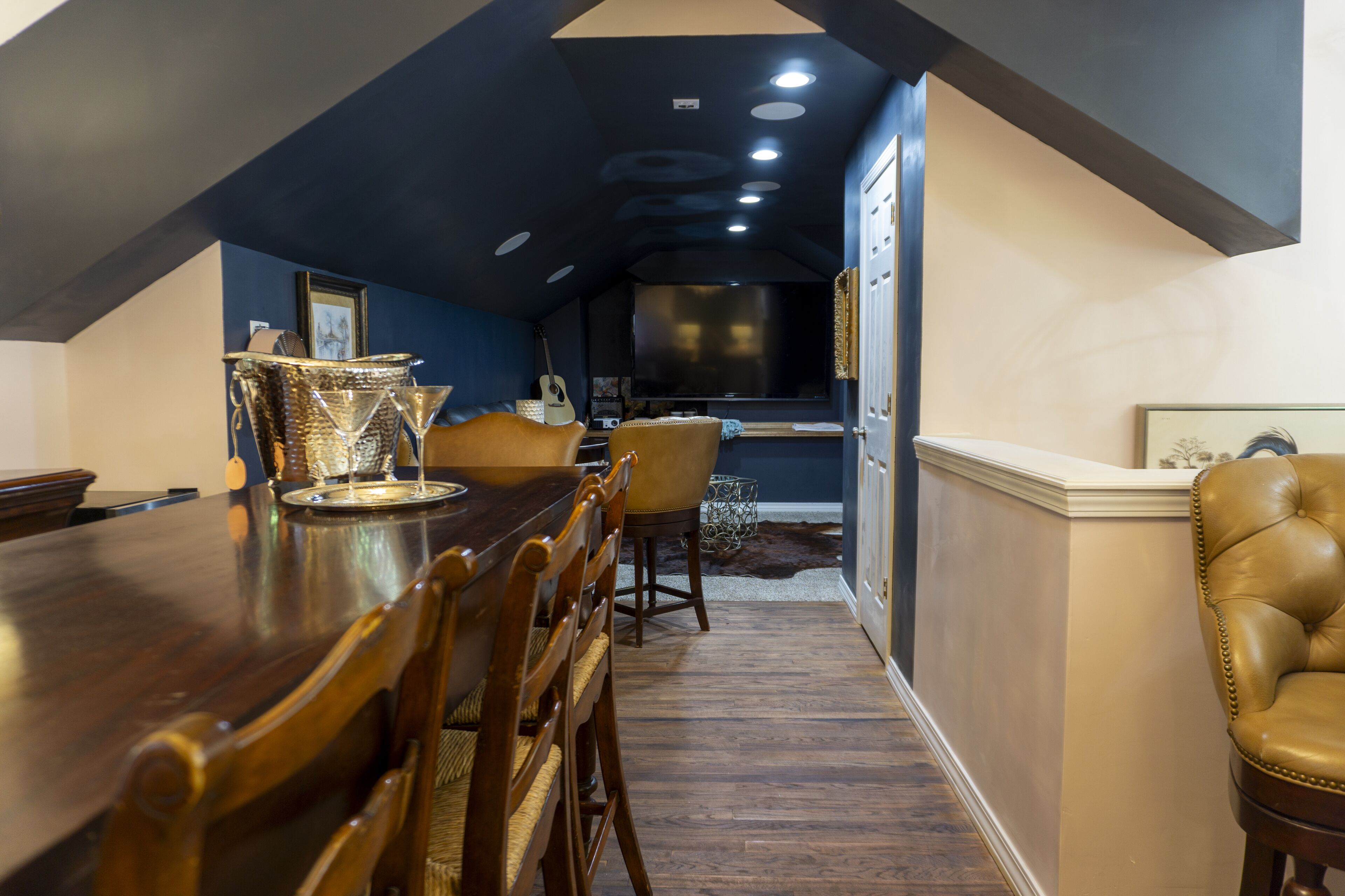 A dining area with a wooden table, chairs, and a decorative metal pitcher.