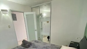 A bedroom with a bed, a wardrobe, and a mirror. - Las Mariposas Suite Apt. 1 (Carolina)
