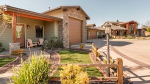 A residential property with a stone facade, a covered porch, and a well-maintained lawn.
