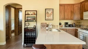 A kitchen with wooden cabinets, a white countertop, and a built-in stove.