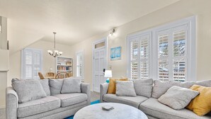 A living room with two grey sofas, a round coffee table, and a blue carpet.