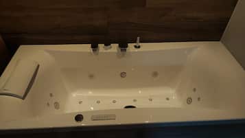 Une baignoire blanche dotée de plusieurs robinets et d’un panneau de commande.