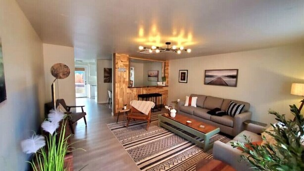 A living room with a sofa, coffee table, and a dining area with a table and chairs.