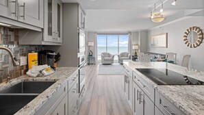 Una cucina moderna con un'isola grande, elettrodomestici integrati e vista all'esterno.