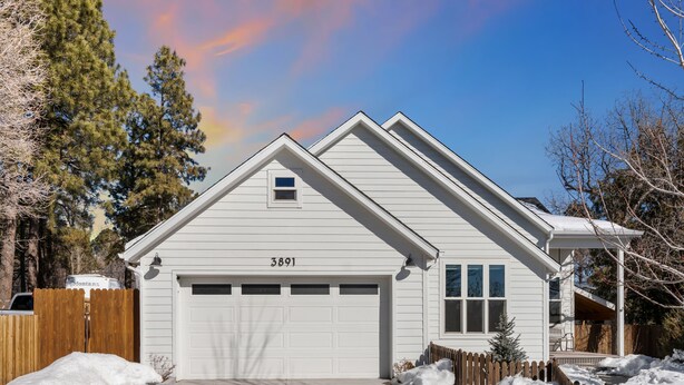 A single-story house with a garage, a number "3891" on the garage door, and a wooden fence surrounding the property.