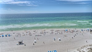 Ein Strand mit Personen, Sonnenschirmen und Rettungstürmen.