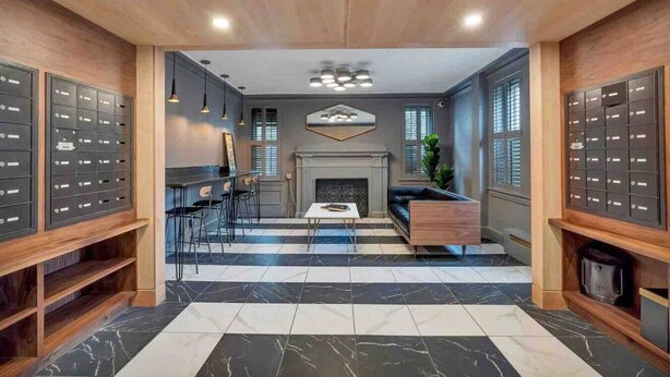 A modern interior with a fireplace, seating area, and storage lockers.