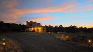 A large building with a flat roof, a driveway, and a few street lamps. - Inviting & Spacious! Unique indoor and outdoor vibe! (Walsenburg)