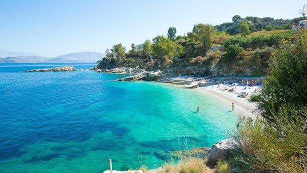 A coastal beach with clear turquoise waters, rocky outcrops, and a few people enjoying the sun. - Appealing 2 Bedroom Villa, A/C, Private Pool, Panoramic Sea Views - In Nissaki, just 450m to Beach! (Nissaki)