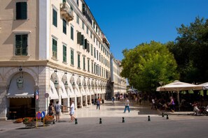 A historic building with a central courtyard, outdoor seating, and a pedestrian area.