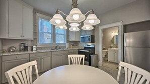 A modern kitchen with a central island, stainless steel appliances, and a chandelier. - Suites on Seneca - Lovely 2 Bed/1 Bath Apartment (Harrisburg)