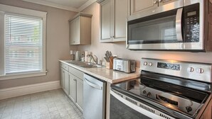 Una cocina con electrodomésticos de acero inoxidable, horno empotrado y microondas.