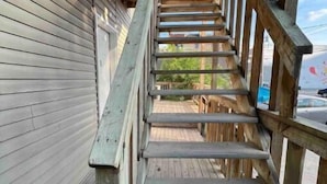 Una escalera de madera que conduce a una terraza con vistas del paisaje circundante.