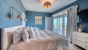 Un dormitorio con una cama grande, un aparador y una ventana con cortinas.