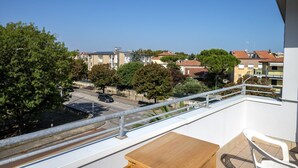 Un balcón con vistas a una zona residencial, una mesa y una silla.