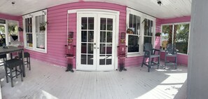 A pink house with a covered porch, white doors, and potted plants. - Charming  Water front Florida Home on the beautiful Pithlachascotee River (Port Richey)