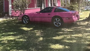 Une maison rose avec une pancarte sur laquelle on peut lire : « La maison de jeux de Barbie ».