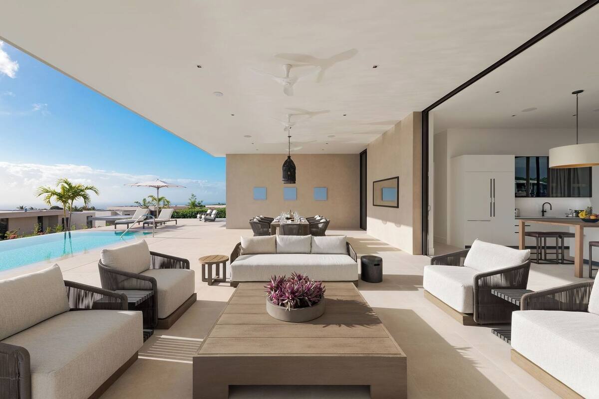 Un espacio al aire libre moderno con piscina, sillones de descanso y zona de comedor.