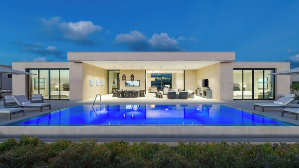 Ein modernes Haus mit Schwimmbad, Essbereich und Wohnzimmer.