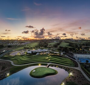 A golf course with a water hazard, well-maintained fairways, and a clubhouse. - Apes Hill Barbados Golf Resort (Orange Hill)