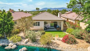 Ein Haus mit Ziegeldach, Schwimmbad und gepflegtem Garten.