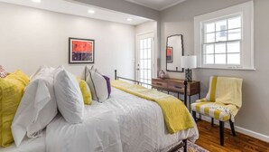 A bedroom with a bed, a chair, a dresser, and a window. - Charming creekside retreat in historic Burlington (Burlington)