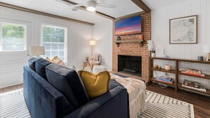 A living room with a sofa, fireplace, and a bookshelf.