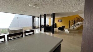 Uma sala de estar espaçosa com uma janela grande, uma escada e um design moderno.