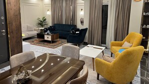 Un salon moderne comprenant un canapé, des fauteuils, une table basse et une table à manger.