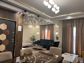 A modern living room with a sofa, a coffee table, and a dining table.