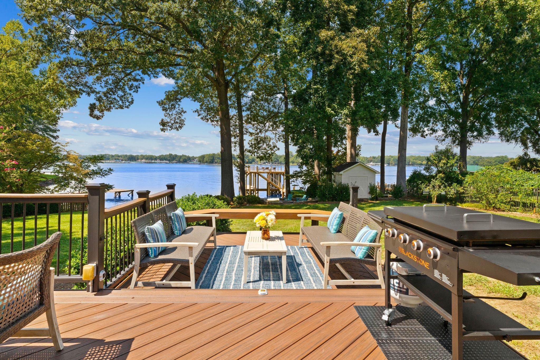 Une terrasse dotée de mobilier d’extérieur, d’un barbecue et offrant une vue sur un lac.