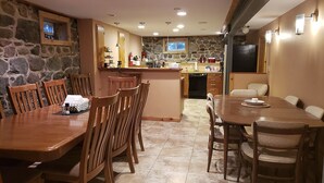 Una cocina amplia con pared de piedra, mesa de madera y sillas.