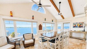 A spacious room with a dining area, a sofa, and a view of the water. - Sunset Pointe - Entertainers Dream with Amazing Lake Norman Views (Terrell)