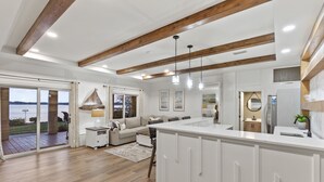 A spacious kitchen with a large island, wooden beams, and a view of the outdoors. - Sunset Pointe - Entertainers Dream with Amazing Lake Norman Views (Terrell)