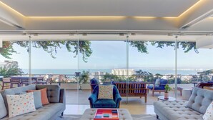 Una sala moderna con un gran ventanal que da a un balcón con vistas a la ciudad.