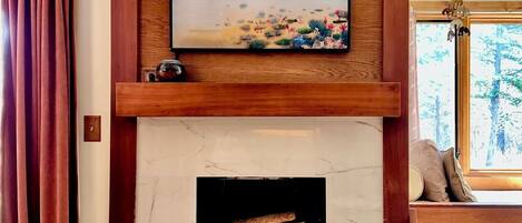 Smart TV, chimenea, libros, estéreo