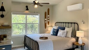 A bedroom with a bed, bedside table, lamp, and a window with a view of trees. - Come Relax at THE CROW'S NEST , Patriot Pointe at Lake Eufaula.  (Eufaula)