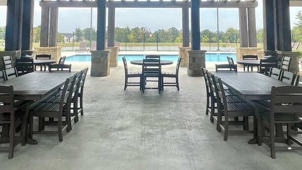 A covered outdoor area with a pool, tables, and chairs arranged for dining or socializing. - Come Relax at THE CROW'S NEST , Patriot Pointe at Lake Eufaula.  (Eufaula)