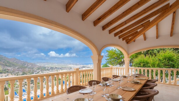 Un coin repas avec une table dressée pour six personnes, offrant une vue sur un paysage magnifique.