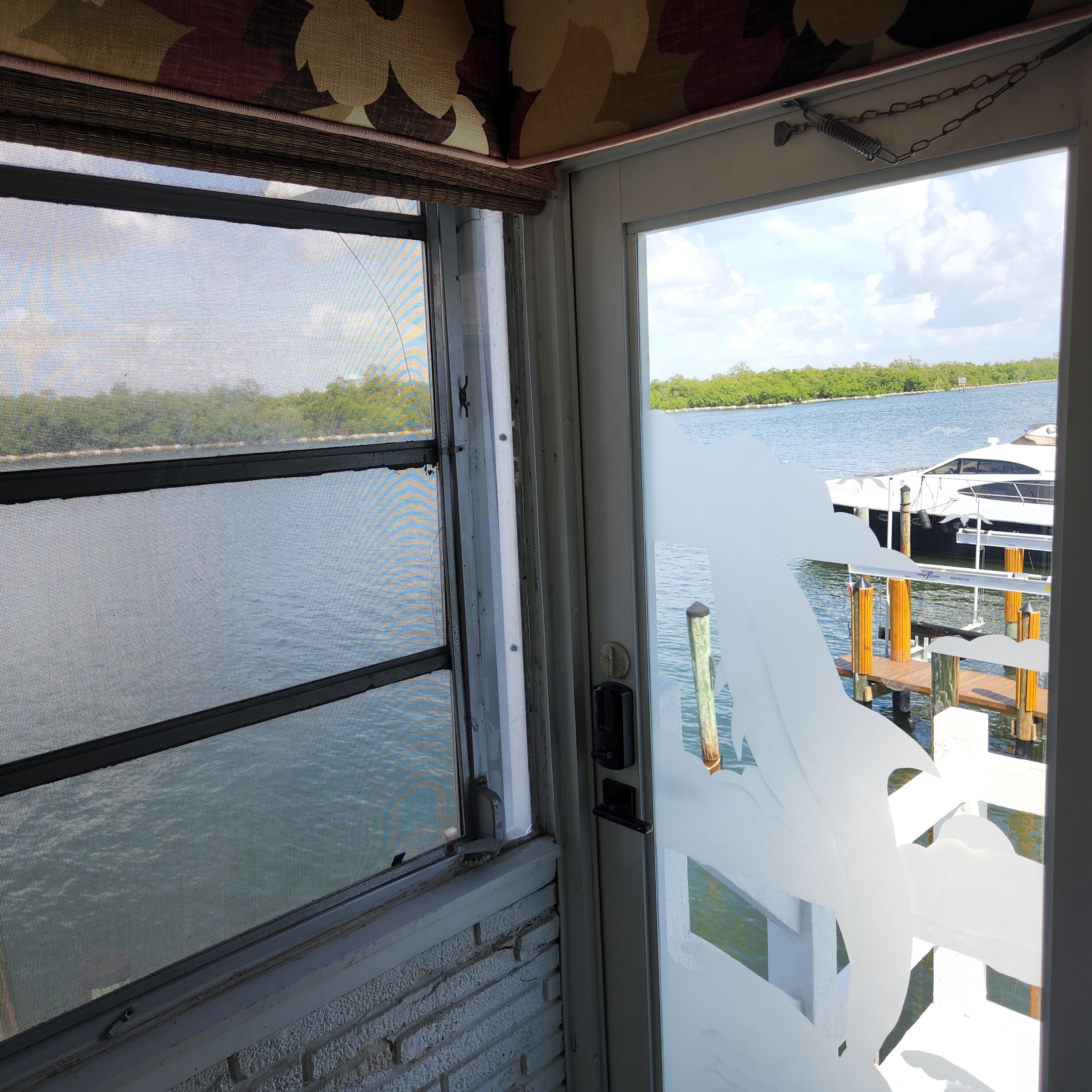 A view from inside a building looking out to a marina with boats docked.
