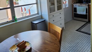 Una cocina con una mesa de comedor, armarios, microondas y horno.