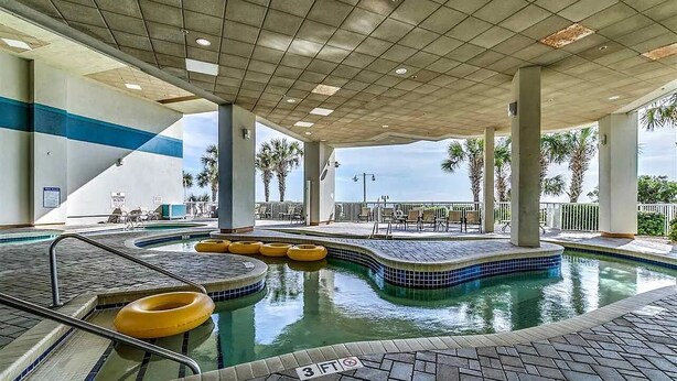 An indoor swimming pool with a tiled floor, yellow floating rings, and a 3 FT depth marker.