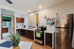 A modern kitchen with a stainless steel refrigerator, a built-in oven, and a microwave.